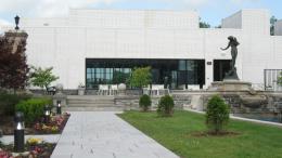 Garden and flowers with bronze statue against a modern white building