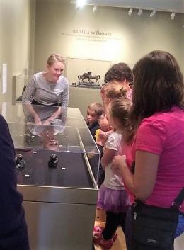 Museum docent talking in art exhibit to young family