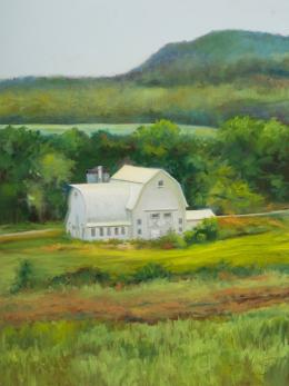 Farm scene featuring a large white barn among rolling green hills 