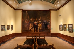 Picture of the interior of a gallery with a large painting in the center